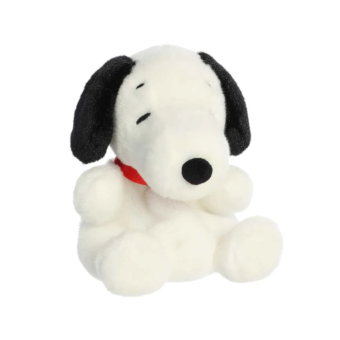 A plush dog wearing a red collar, positioned on a white surface, highlighting its adorable features and friendly demeanor.