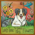 Wall art plaque of a dog in a garden with flowers and a butterfly, featuring the text 'Take Time to Smell the Flowers'.