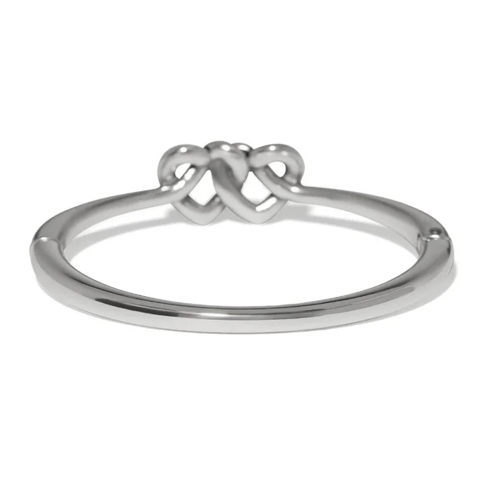 Polished silver Interlok linked hearts hinged bangle featuring intertwined heart motifs with a sleek, elegant design.
