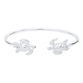 Pair of silver turtle-shaped bangles on a white background