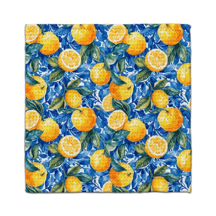 A blue and yellow patterned towel featuring vibrant oranges scattered across its surface.