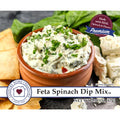 A bowl of feta spinach dip mix with fresh spinach and crumbled feta cheese, ready for serving with crackers.