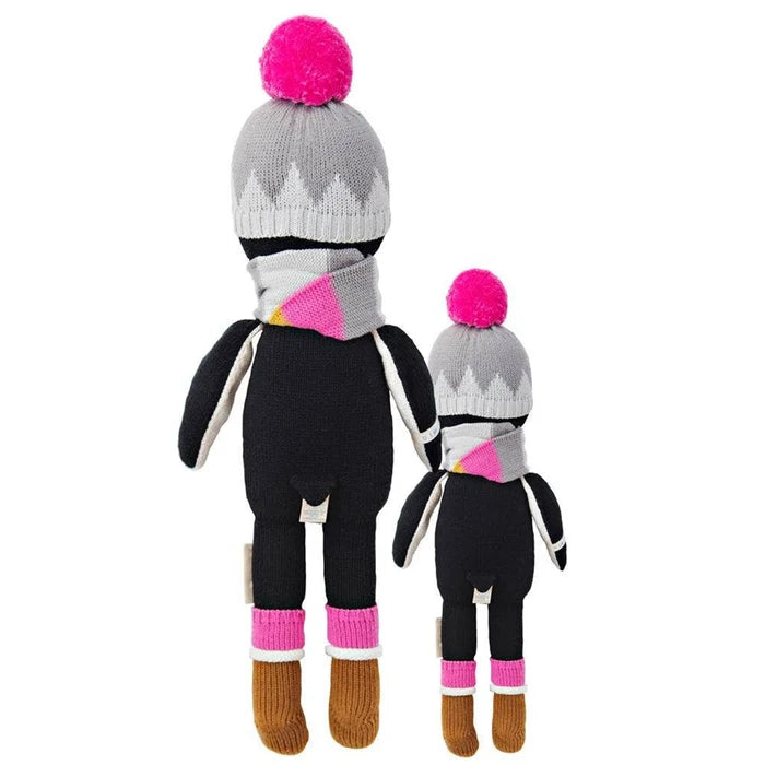 Back view of two Cuddle + Kind Aspen the Penguin dolls showing their gray knit hats with pink pom-poms and black flipper arms.