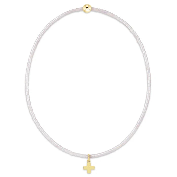"This beautifully crafted pink beaded bracelet featuring a delicate gold-tone cross charm."