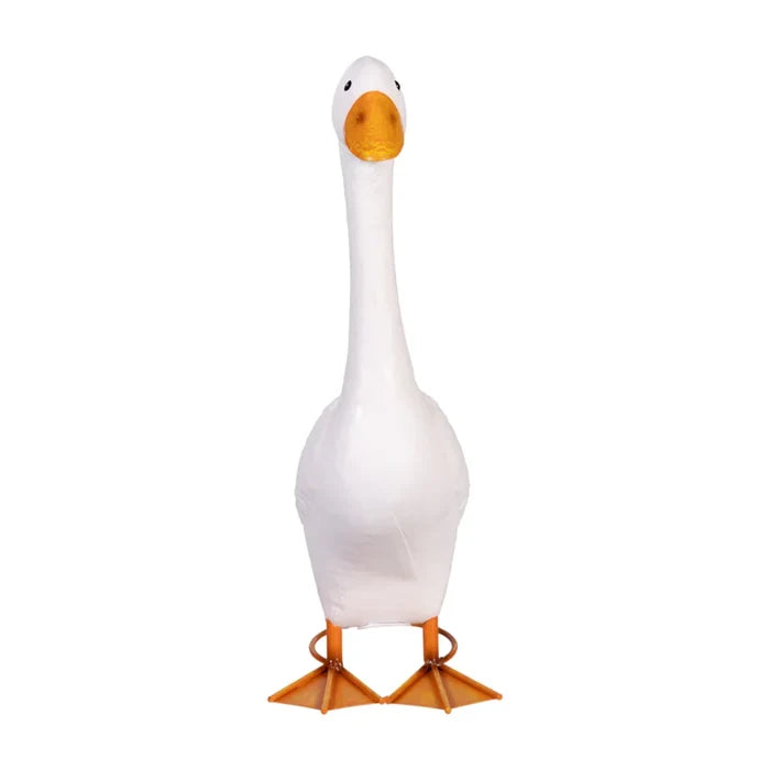 A white goose with an orange beak and orange legs standing on grass.