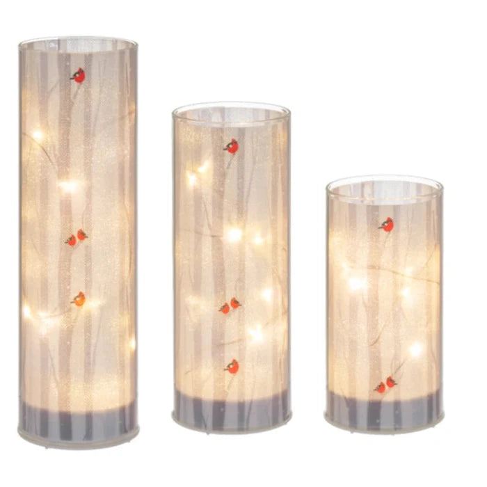 The Ganz LED Light Up Cardinal on Birch Tree Pillar Set features a vibrant red cardinal perched on a beautifully detailed birch tree pillar illuminated by soft LED light.