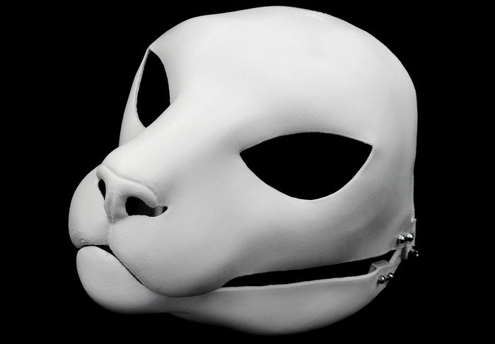 Photo showing a white, plastic 3D printed small feline fursuit head base complete with metal hardware at a 3/4 angle against a black background.