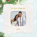 Decorative photo ornament with a couple's picture and 'Best love story ever' text, surrounded by Christmas tree branches.