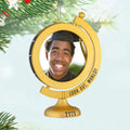 Gold graduation-themed ornament with a photo of a person and 'Look Out, World! 2026' text, hanging on a Christmas tree.