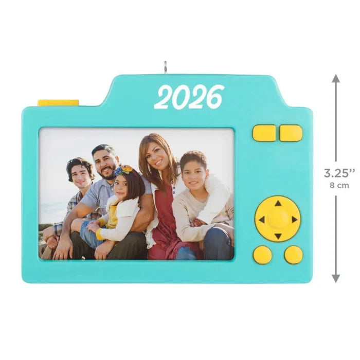 Turquoise camera-shaped photo frame with a family photo and '2026' on a white background