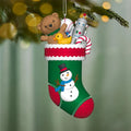 Christmas stocking ornament with teddy bear, robot, and candy on a blurred green background