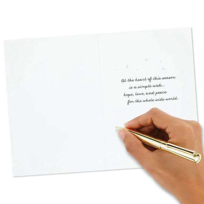 Hand holding a gold pen over a white card with a message on a white background