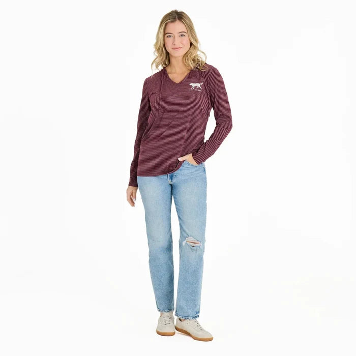 Woman wearing a maroon striped long-sleeve shirt and light blue jeans on a white background