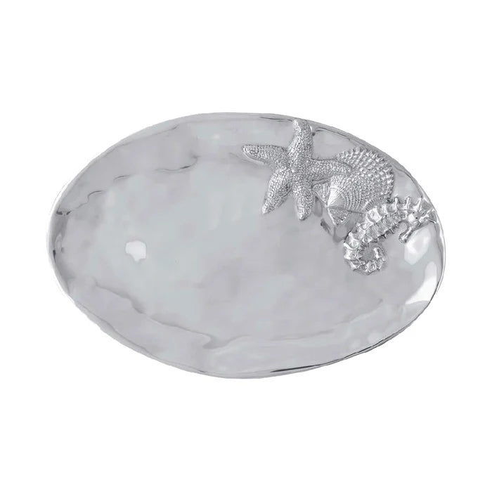 A silver plated oval tray displaying a starfish and a shell, elegantly arranged for decorative purposes.