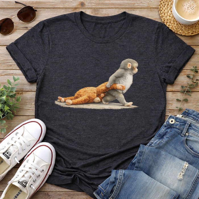 Dark gray t-shirt with a graphic of a monkey and bear, placed on a wooden surface with shoes and jeans around.