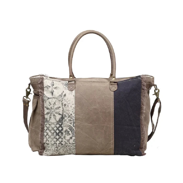 Canvas vintage bag embellished with multiple patches, highlighting a distinctive and creative design.
