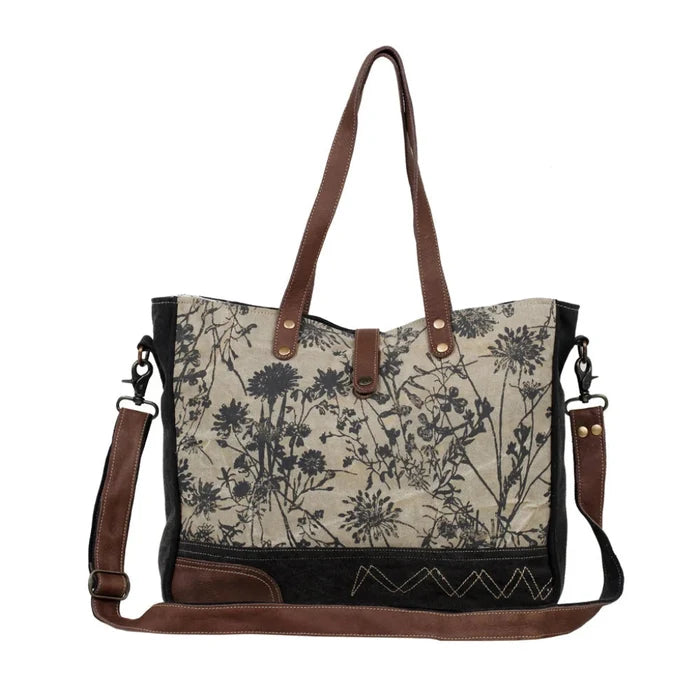 The Myra Bag Mystique Messenger Bag features upcycled woven canvas with rich leather accents.