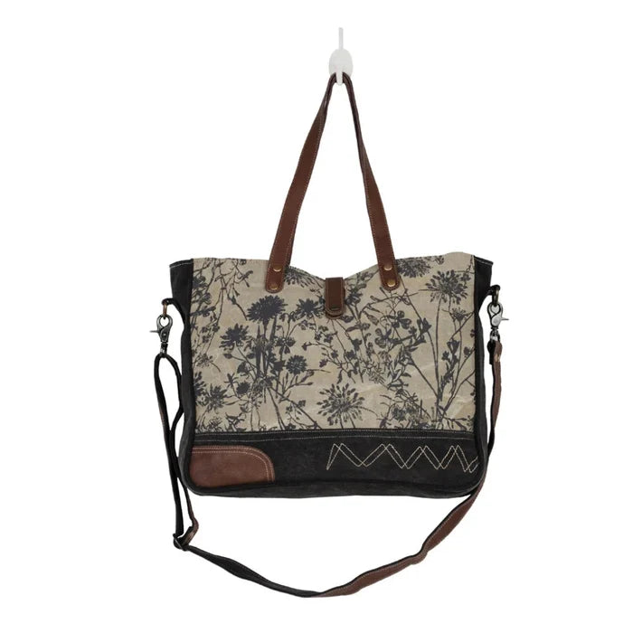 The Myra Bag Mystique Messenger Bag features upcycled woven canvas with rich leather accents.