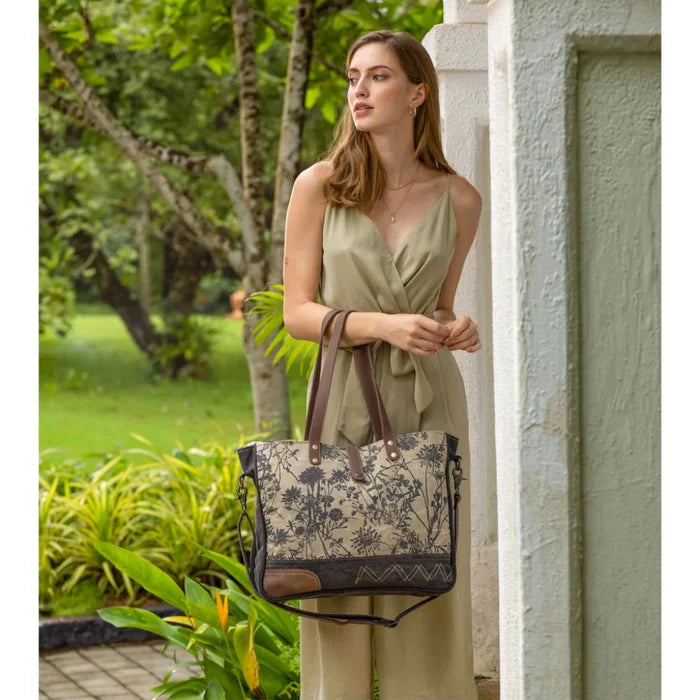 The Myra Bag Mystique Messenger Bag features upcycled woven canvas with rich leather accents.