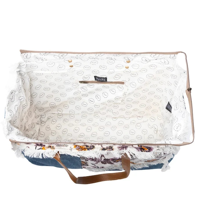 This Myra Bag Venture Weekender Bag features a vintage paisley-inspired printed canvas body in neutral gray tones.