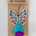 A butterfly-shaped air freshener with a decorative tassel hanging from it.