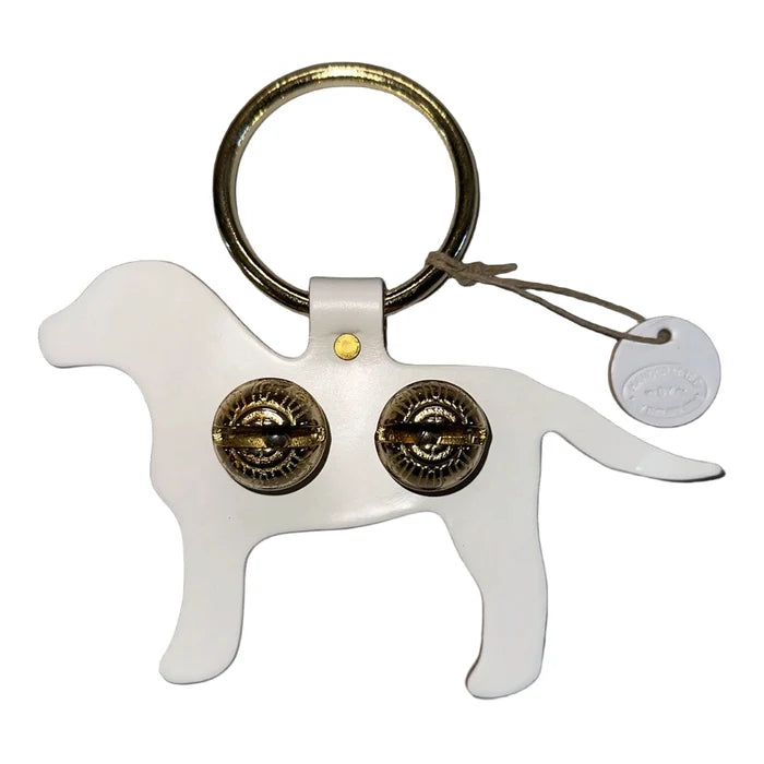 Dog-shaped keychain with brass bell on a black background