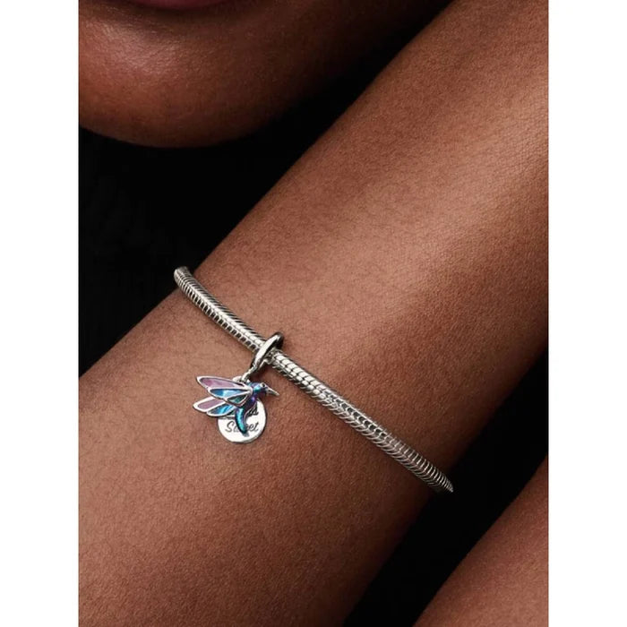 Person wearing Pandora Hummingbird Double Dangle Charm on a sterling silver bracelet.
