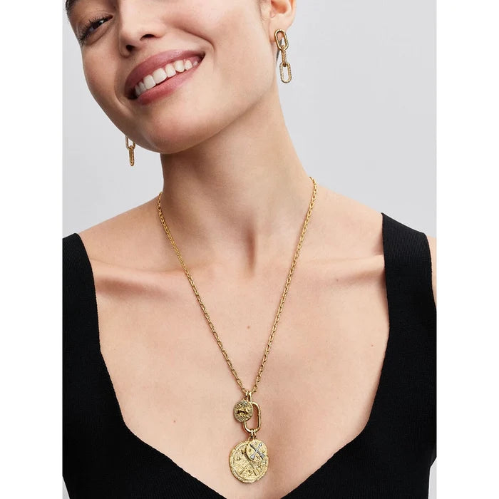 Smiling woman wearing Pandora gold necklace and earrings with Talisman medallion charms.
