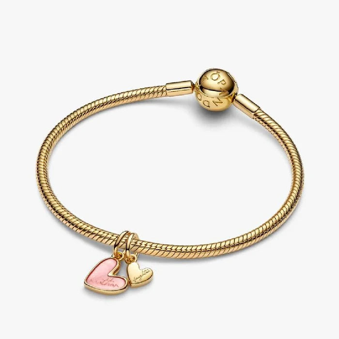 A heart charm embellished with bright pink enamel, highlighting its delicate and attractive design.