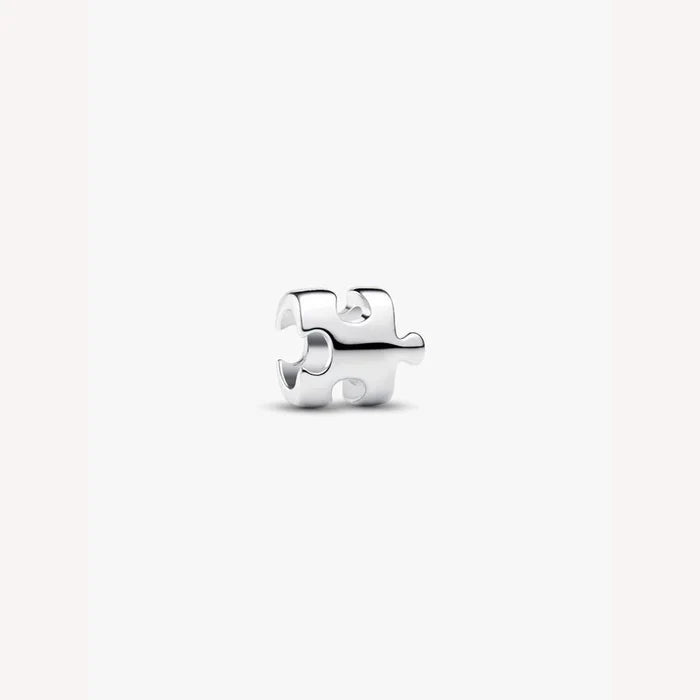 Silver puzzle piece charm on a light background