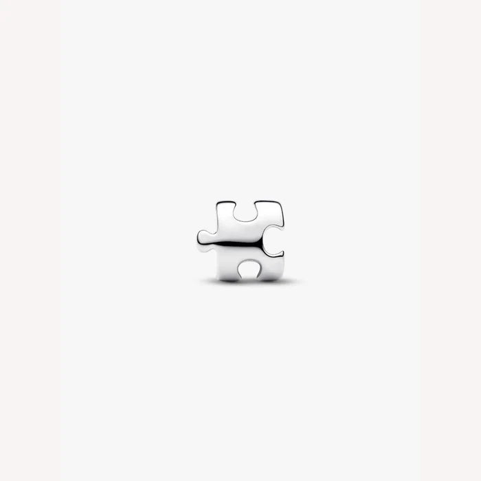 Silver puzzle piece charm on a light background
