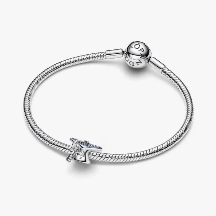 Silver graduation cap charm on a light background
