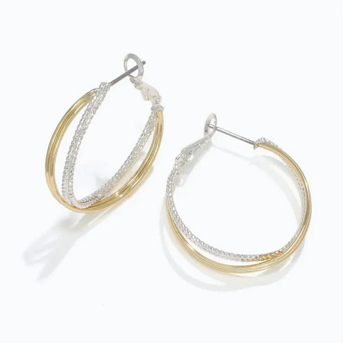 Periwinkle two-tone twisted hoop earrings featuring an elegant intertwined design with contrasting metal finishes.