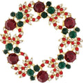 Rain Jewelry gold-tone Christmas wreath brooch featuring red and green crystal accents in a festive holiday design.