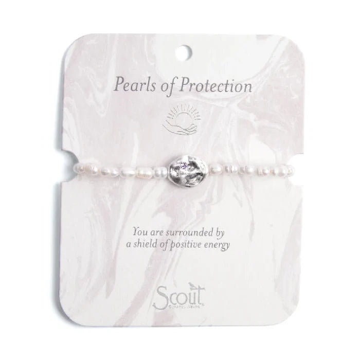 A white pearl bracelet featuring a single purple stone accent.