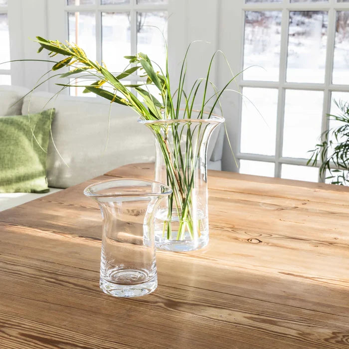 1. A table featuring a vase of colorful flowers alongside a clear glass of water.