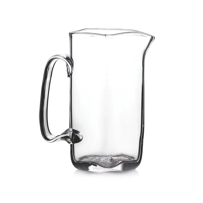 Clear glass pitcher with a handle, set against a plain white background.