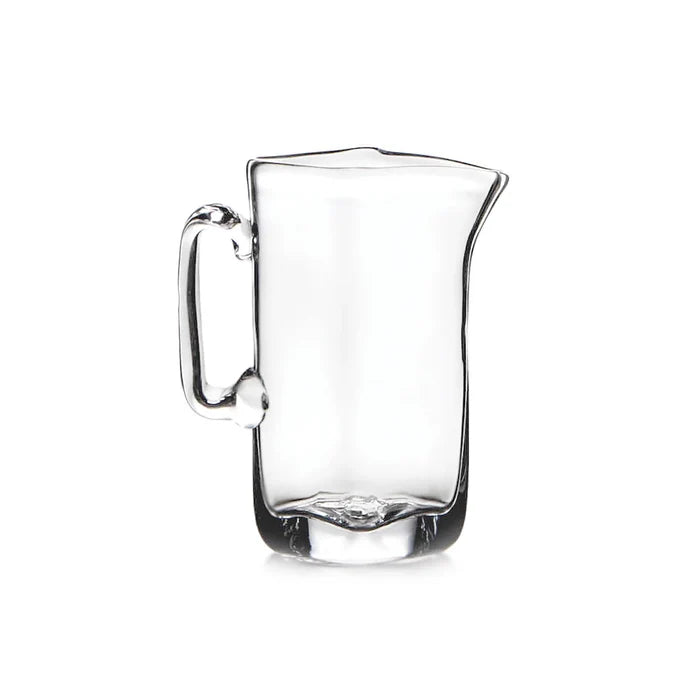Clear glass pitcher with a handle, showcasing a simple and elegant design for serving beverages.