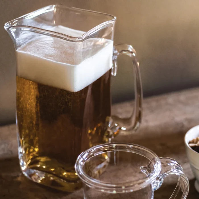 Glass pitcher with a handle, designed for easy pouring and serving of liquids.