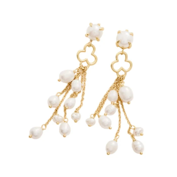 A pair of gold tassel earrings featuring white beads and floral-shaped accents.