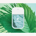 Touchland power mist bottle on a green leaf background