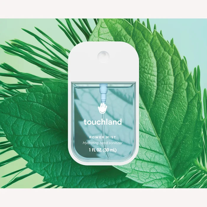 Touchland power mist bottle on a green leaf background