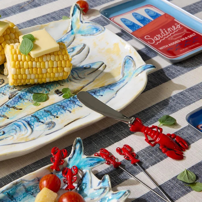 Two red lobster cutters on a blue and white striped table covering.
