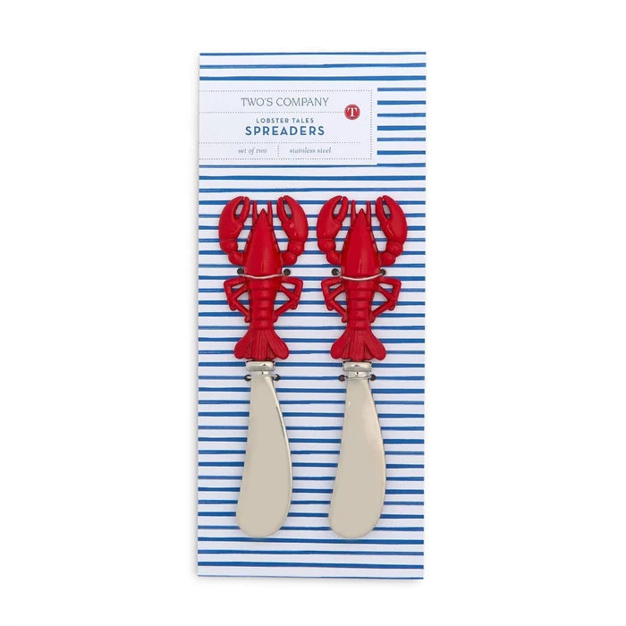 Two red lobster-shaped cutlery pieces rest on a striped tablecloth, adding a playful touch to the dining setting.