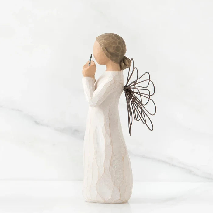 A willow tree angel with a heart, embodying themes of love and peace in a natural environment.