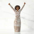 A figurine of a woman with her arms raised, expressing joy or celebration.