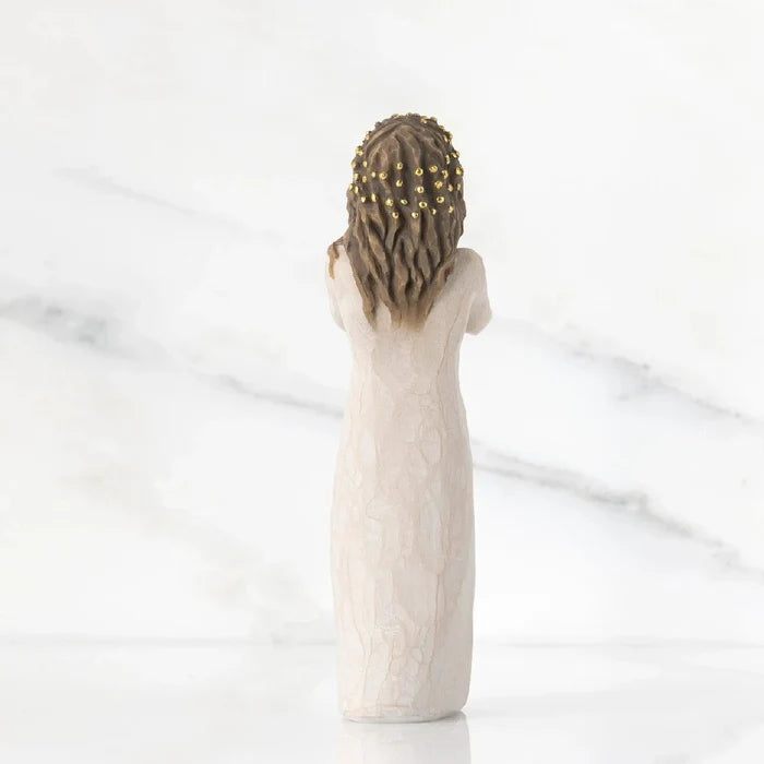 A decorative figurine depicting a woman in a white dress, highlighting her poised stance and delicate features.