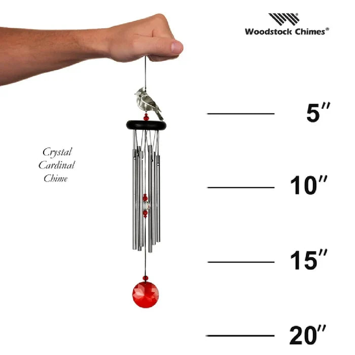 A red and white bird near a wind chime, capturing a moment of nature's beauty and tranquility.